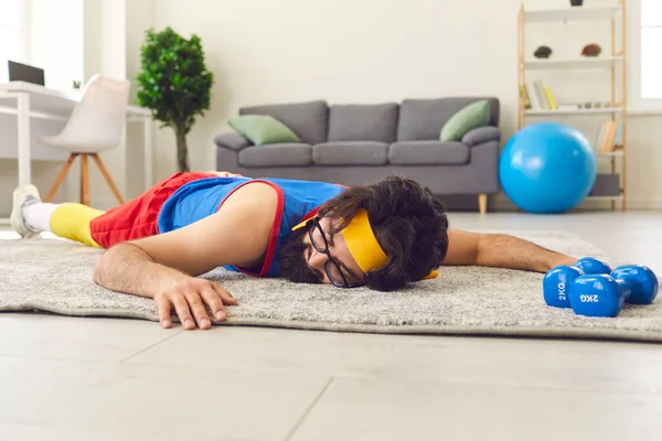 Joven deportista cansado y desmotivado tumbado en el suelo después de abandonar el entrenamiento físico con pesas — Foto de Stock