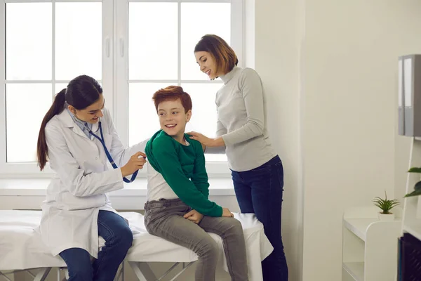 Familjeläkare lyssnar på andedräkt av liten patient under kontroll på kliniken — Stockfoto