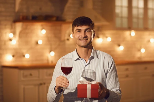Jovem feliz namorado sentado com vinho e presente de férias durante namoro on-line — Fotografia de Stock