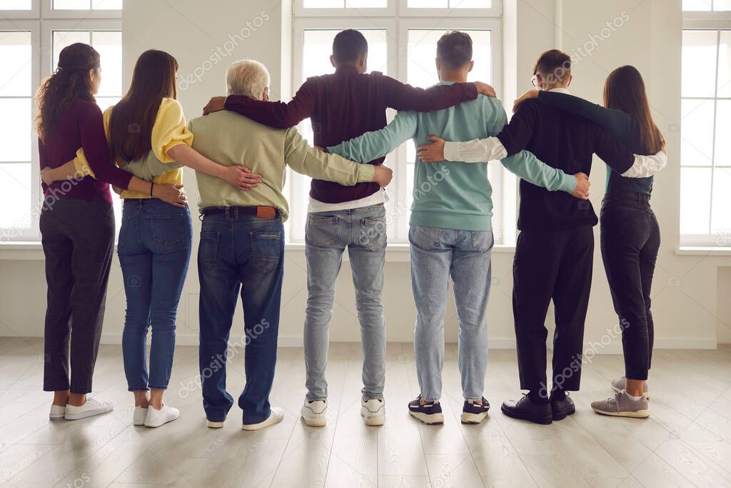 Team of confident people standing together and hugging ready to support each other