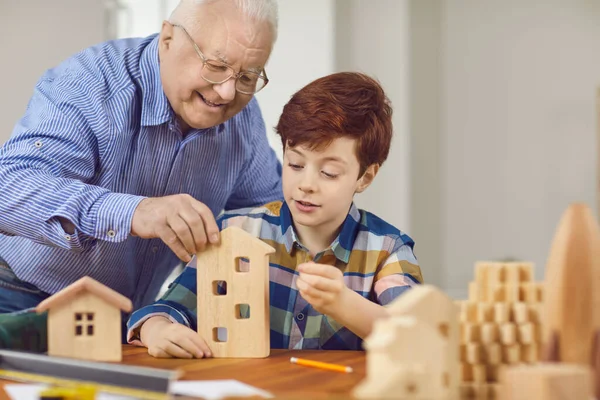 Felice nonno e suo nipote fare case giocattolo in legno in falegnameria — Foto Stock