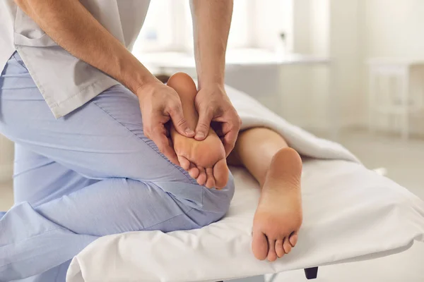 Ręce terapeuty wykonującego zabieg akupresury lub ręcznego masażu stóp pacjenta — Zdjęcie stockowe