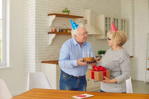 一对头戴节日礼帽的快乐的老夫妇在家里准备生日派对 — 图库照片