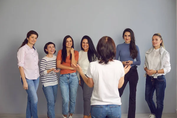 Mujeres jóvenes positivas escuchando un interesante discurso motivacional del entrenador profesional —  Fotos de Stock