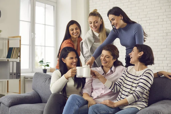 Grupp glada unga kvinnor dricker kaffe, skrattar och njuter av kul tid tillsammans — Stockfoto