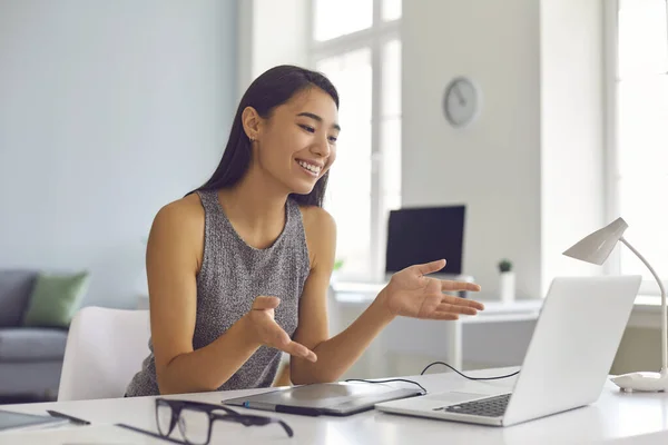 Heureuse jeune femme asiatique assise au bureau à la maison et utilisant un ordinateur portable pour un appel vidéo — Photo