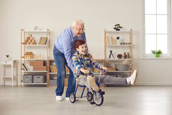 Happy grandfather and grandson playing together, fooling around and having fun at home