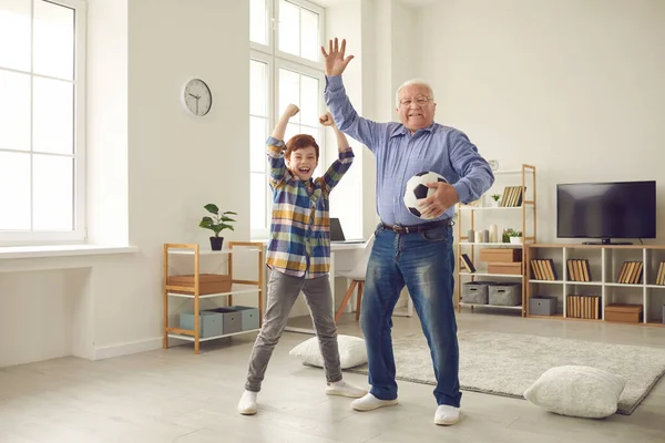 Avô e neto alegres desfrutando de tempo livre e jogando futebol juntos — Fotografia de Stock