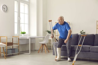 Koltuğundan kalkıp koltuk değnekleriyle yürümeye çalışan kırık bacaklı son sınıf öğrencisi.