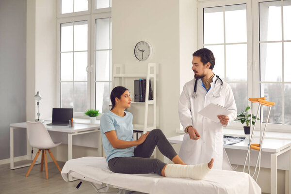 Хирург-ортопед опрашивает женщину со сломанной ногой и дает ей советы по выздоровлению