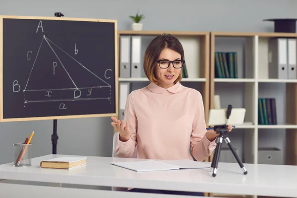 Profesora femenina de matemáticas y geometría explica nuevo material a los estudiantes a través de una videollamada. — Foto de Stock
