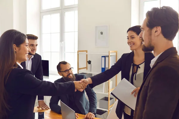 Gente de negocios feliz cerrando trato y estrechando las manos después de la reunión de negociación en la oficina — Foto de Stock