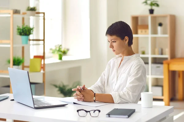 Young woman watching educational video or attending webinar using laptop computer — Stock Photo, Image