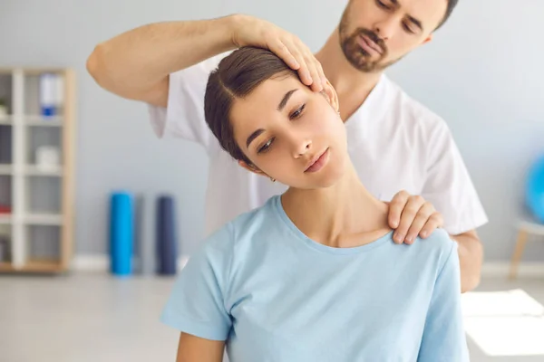 Hombre médico quiropráctico u osteópata ajuste mujeres articulaciones del cuello con las manos durante la visita y el tratamiento —  Fotos de Stock