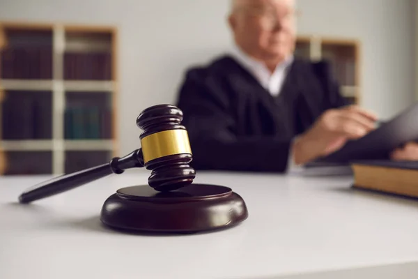 Close-up de martelo de madeira colocado no bloco de som na mesa dos juízes durante audiência judicial — Fotografia de Stock