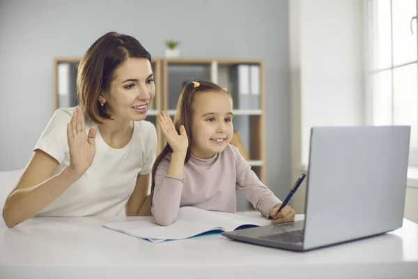 Mãe feliz e filha acenando as mãos no laptop, cumprimentando professor em aula on-line — Fotografia de Stock