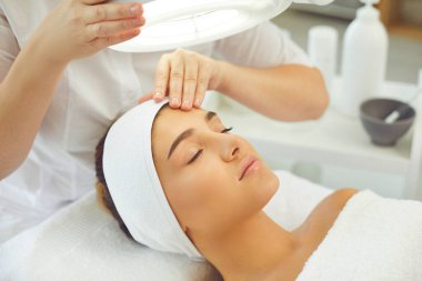 Modern kuaförde profesyonel güzellik prosedürlerinden zevk alan güzel bir genç kadın.