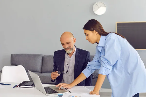 Homem de negócios maduro e mulher trabalhador de escritório olhando para a tela do laptop e discutindo projeto — Fotografia de Stock