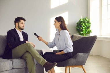 Gazeteci ya da TV sunucusu ünlü ya da iş adamı ile röportaj yapıyor.