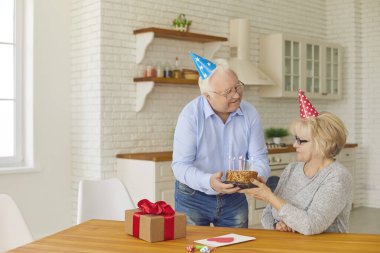 Romantik yaşlı adam bir dilek tutsun ve mumları üflesin diye karısına pasta veriyor. Renkli şapkalı yaşlı çift evde doğum gününü ya da yıldönümünü kutluyor..