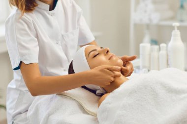 Terapist, parmakları olan genç bir kadına profesyonel elle masaj yapıyor.