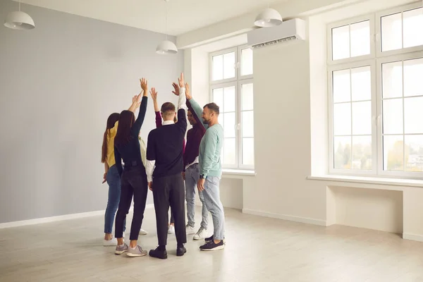 Lag av glada människor som står på kontoret, firar framgång och high-fiving varandra — Stockfoto