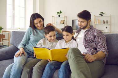 Mutlu ve çocuklu bir aile evde hafta sonunun tadını çıkarırken ilginç bir kitap okuyor.