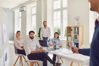 Meslektaşları onu ofis masasında otururken dinlerken genç adam bir şey tartışıyor..