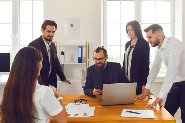 Team di giovani che si riuniscono attorno al tavolo dell'ufficio e discutono il loro progetto di business — Foto Stock