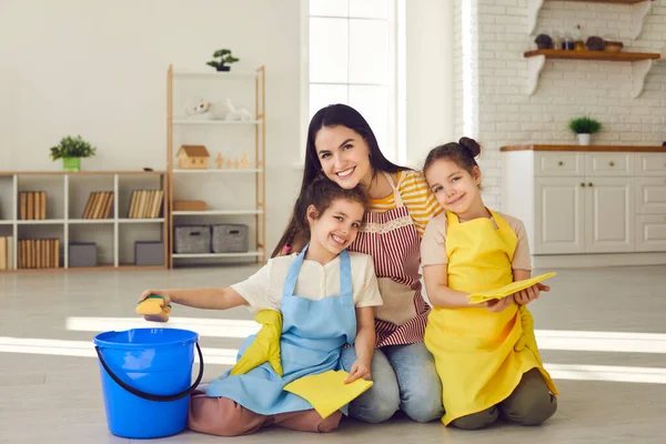 Ibu dan anak perempuan yang bahagia duduk di lantai dengan kain lantai dan tersenyum di depan kamera — Stok Foto