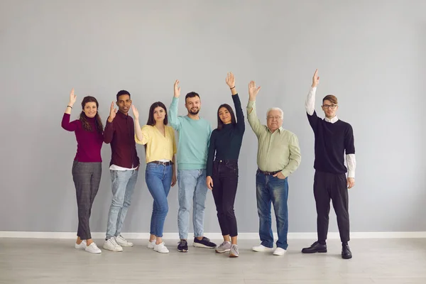 Група щасливих багаторасових людей, які піднімають руки, голосують за хорошу пропозицію — стокове фото