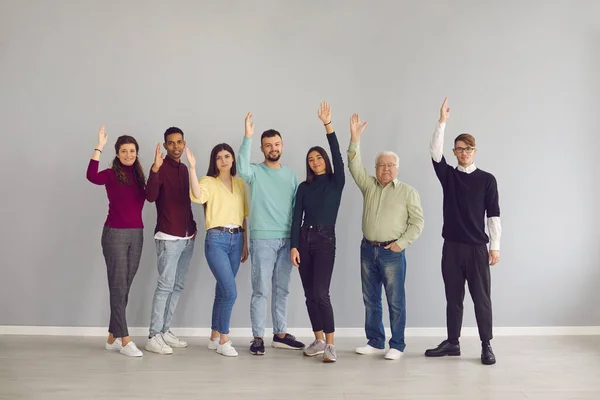 Grupo de pessoas multirraciais felizes levantando as mãos votando por uma boa sugestão — Fotografia de Stock