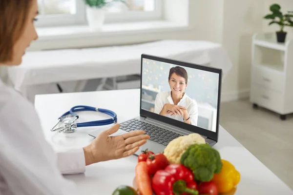 Női orvos táplálkozáskutató kommunikál a női beteg online videojáték közben — Stock Fotó