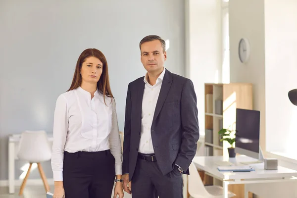 Retrato de socios de negocios millennials confiados mujer y hombre de pie en la sala de oficinas. —  Fotos de Stock