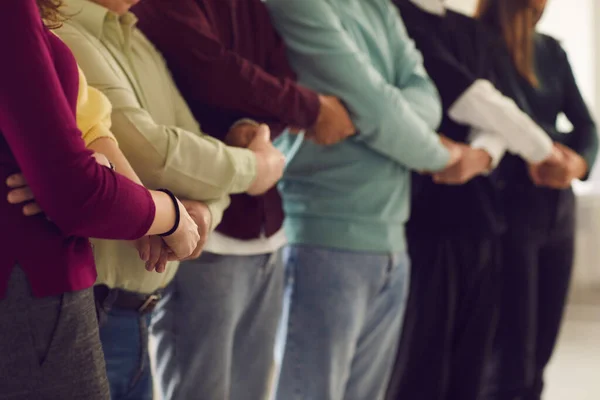 Groep mensen die samen staan en elkaars hand vasthouden, elkaar steunen en hun eenheid tonen — Stockfoto