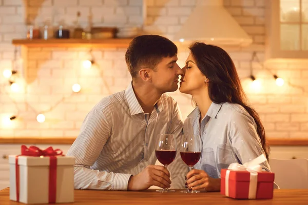 Jovem casal amoroso homem e mulher sentados beijando uns aos outros durante a celebração do dia dos namorados — Fotografia de Stock