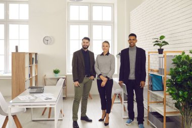 İş merkezindeki kameraya bakan çok ırklı ofis çalışanlarının portresi..