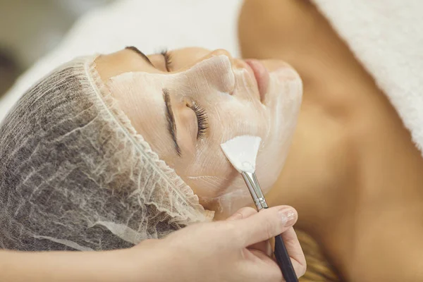 Close-up of womans face during beauty procedure of moisturizing mask applying — Stock Photo, Image