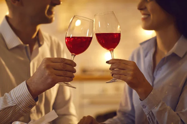 Homem e mulher apaixonados desfrutando de vinho tinto e copos na noite romântica em casa — Fotografia de Stock