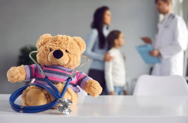 Schattige teddy met stethoscoop zittend op tafel in kliniek of kinderziekenhuis — Stockfoto