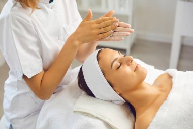 Kadın dermatolog nemlendirici krem sürerek cilt bakımına devam ediyor.