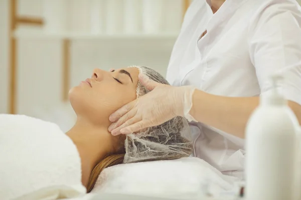 Manos de massuer haciendo lifting facial masaje para mujer joven — Foto de Stock