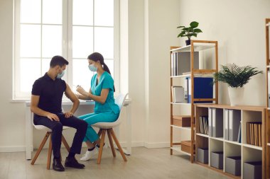 Hastanede mevsimsel aşı kampanyası sırasında aşı enjekte eden hemşire.