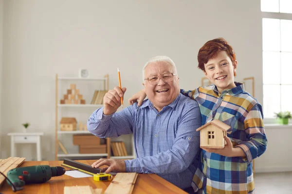 Felice nonno e nipote ragazzo rendendo misure per birdhouse in legno insieme — Foto Stock