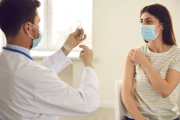 Doktor, klinikte aşı kampanyası sırasında aşıyla şırınga hazırlıyor. — Stok fotoğraf