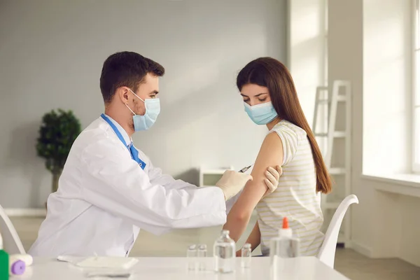 Infirmière injectée à une jeune femme pendant la campagne de vaccination au centre de santé — Photo