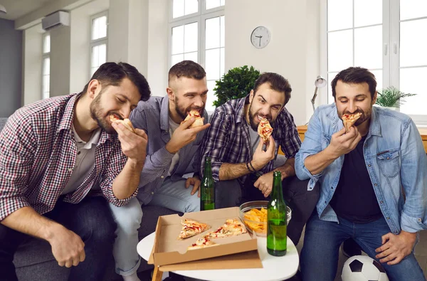 Groep hongerige jonge vrienden die sport kijken, bier drinken en pizza eten — Stockfoto