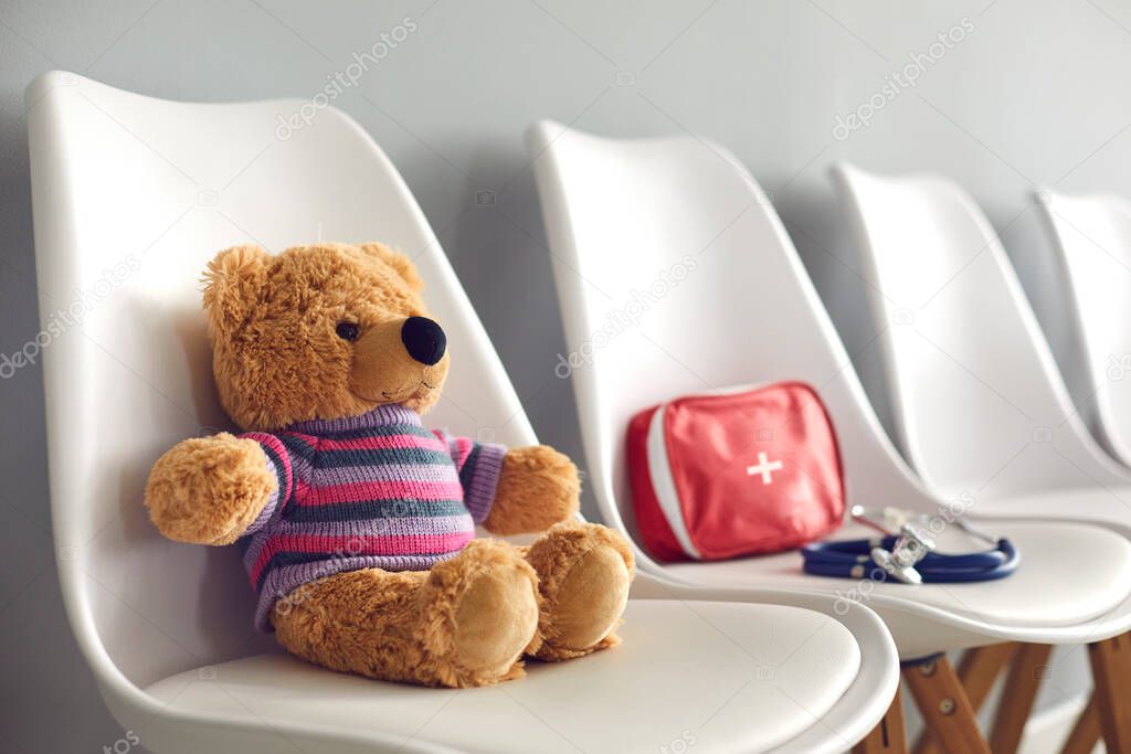 First-aid kit, stethoscope and cute teddy in waiting room of childrens medical center