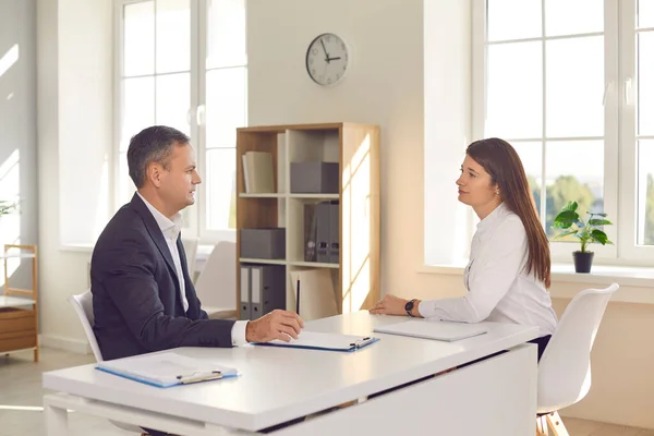 Uomo d'affari che discute il progetto con il responsabile donna o intervistando il candidato per il posto vacante in ufficio — Foto Stock