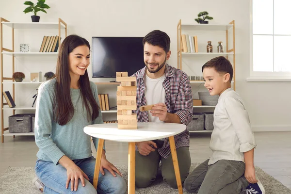 Szczęśliwa mama, tata i dziecko cieszą się wolnym czasem w weekend i wspólnie grają w jengę — Zdjęcie stockowe